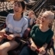 Smiling young people riding a roller coaster